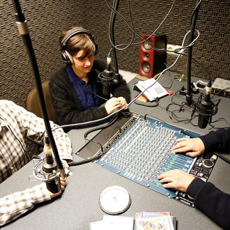 Geschäftsführer heiko Kunert und Pressereferentin Melanie Wölwer werden vom Leiter der Radiogruppe, Ralf Bergner, im Radiostudio des Louis-Braille-Centers interviewt