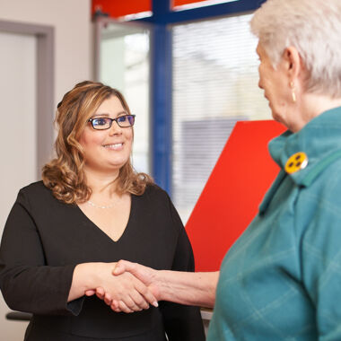 Die Mitarbeiterin am Empfang des BSVH, Tamara Geißler, begrüßt eine Besucherin im Louis-Braille-Center